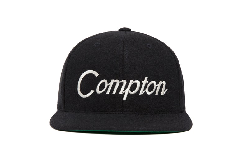 Peut inclure: Une casquette de baseball en laine noire avec un script cursif brod&eacute; en blanc qui dit "Compton".
