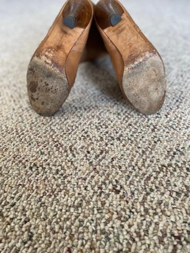 Puede incluir: Un par de botas de cuero marr&oacute;n con punta puntiaguda y tac&oacute;n bajo. Las botas est&aacute;n gastadas y tienen un aspecto desgastado.