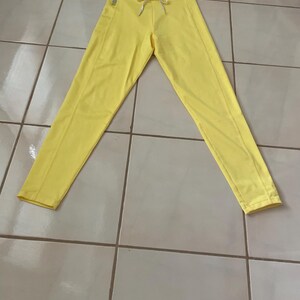 May include: A pair of yellow sweatpants with a drawstring waist.
