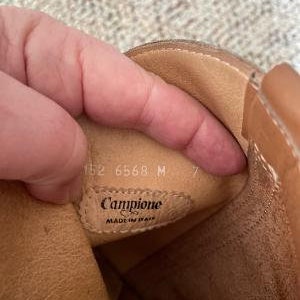 Puede incluir: Primer plano del interior de una bota de cuero marr&oacute;n con el texto "Campione Made in Italy" y los n&uacute;meros "152 6568 M 7" visibles.