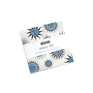 May include: A pack of 5-inch fabric squares featuring a white background with blue and black stylized suns with faces. The fabric squares are labelled "starry sky" by April Rosenthal of Prairie Grass Patterns for Moda Fabrics.