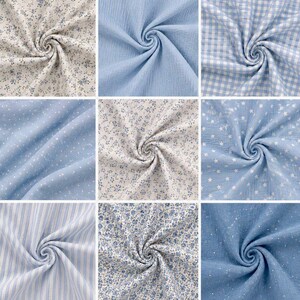 May include: Nine swatches of fabric in various light blue and white patterns. Designs include small floral prints, polka dots, gingham, stripes, and star patterns. The fabrics are swirled to show texture and drape, suitable for sewing or crafting projects.