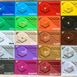 May include: A collection of 16 plastic cards, each with a different color and texture. The cards are arranged in a grid pattern and labeled with the color names in German. The colors include dark blue, light blue, red, yellow, green, apple green, orange, black, white, beige, copper, brown, marble gray, purple, gold, silver, gold green, magenta, metallic red, and natural.