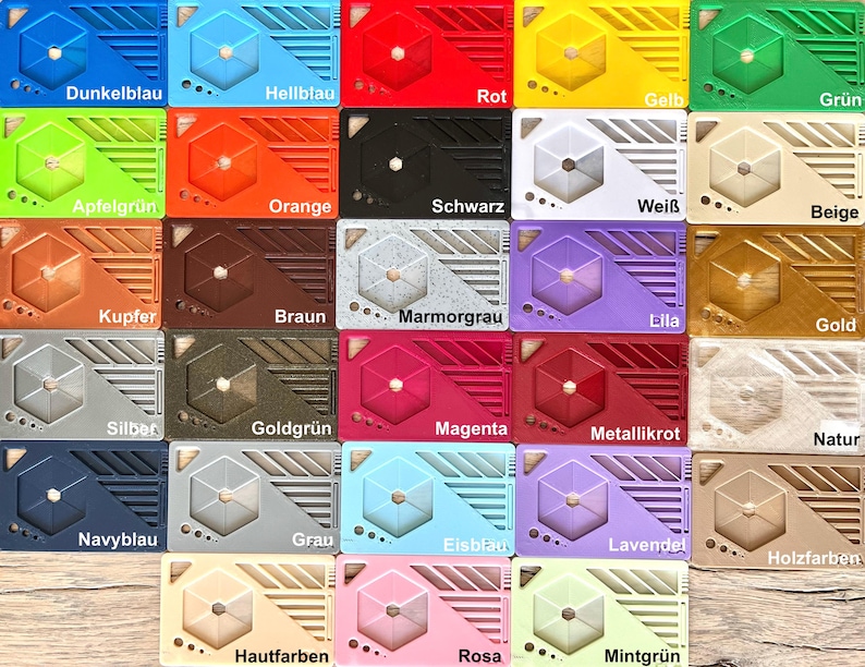 K&ouml;nnte beinhalten: Eine Sammlung farbenfroher, rechteckiger Objekte, die jeweils ein geometrisches Design und ein zentrales Sechseck aufweisen. Die Objekte sind in verschiedenen Farben erh&auml;ltlich, darunter Blau, Rot, Gr&uuml;n, Orange und mehr, mit deutschen Farbbezeichnungen.