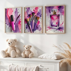 May include: Three framed watercolour prints of beauty products: a lipstick, makeup brushes, and a perfume bottle. The prints feature pink and purple splashes. Two teddy bears sit on a white dresser below the artwork.