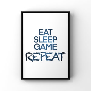May include: A black framed print with the text "Eat Sleep Game Repeat" in blue text with a gradient effect.