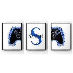 May include: Three framed prints with a blue watercolour background. The left and right prints feature a black silhouette of a video game controller. The centre print features a blue letter 'S' with the name 'SAMUEL' in black text.