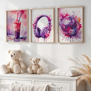 Op de afbeelding: Drie ingelijste aquarelprints met een thema van paars en roze. Eén toont bubble tea, een andere een koptelefoon en de laatste een discobal. Twee teddyberen zitten onder de prints op een witte commode.