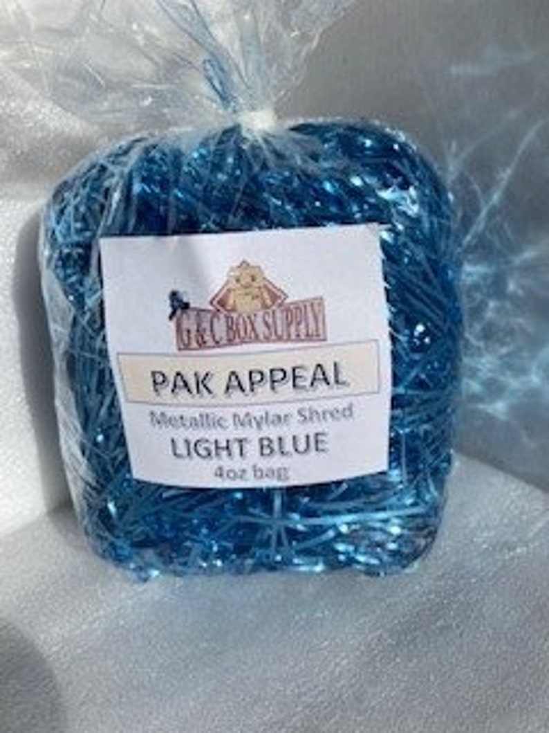 May include: A 40 oz bag of light blue metallic mylar shred, labeled "PAK APPEAL Metallic Mylar Shred Light Blue 40 oz bag".