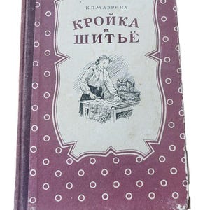May include: A vintage hardcover book with a purple cover featuring a white polka dot pattern. The center displays a white rectangular label with the text K.P. MAVRINA KROIKA I SHITE and a black and white illustration of a person sewing at a table.