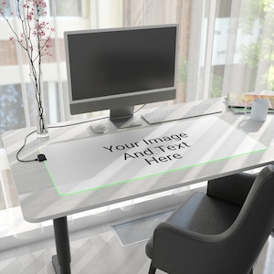 May include: A white desk mat with a green border and the text "Your Image And Text Here" on a white desk with a computer, keyboard, and mouse. A black office chair is in the foreground.