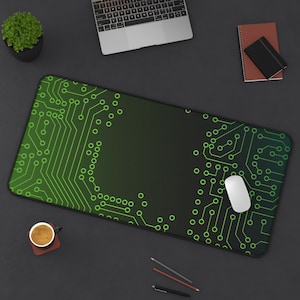 May include: A green and black mouse pad with a circuit board design. The mouse pad has a gradient effect, fading from dark green to light green. A white computer mouse is on the mouse pad.