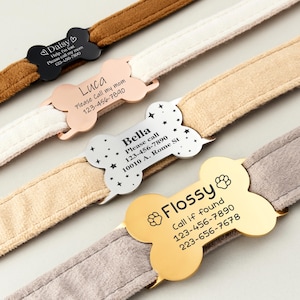 May include: Four different dog collar tags with bone shapes and engraved text. The tags are black, rose gold, silver, and gold. The text includes the dog's name, phone numbers, and instructions for what to do if the dog is found.