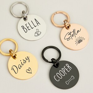 May include: Four personalized dog tag keychains with different names and designs. The keychains are silver, gold, rose gold, and black.