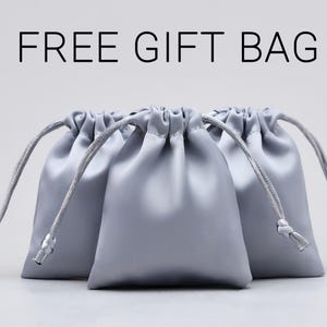 May include: Three silver satin drawstring bags with white cords. FREE GIFT BAG.