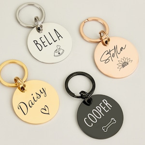 May include: Four personalized dog tag keychains with different names and designs. The keychains are silver, gold, rose gold, and black.