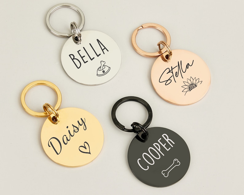 May include: Four personalized dog tag keychains with different names and designs. The keychains are silver, gold, rose gold, and black.