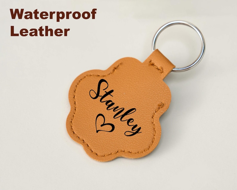 May include: Tan leather paw-shaped keychain with a silver key ring. The keychain is personalized with the name "Stanley" in black script and a small heart. The words "Waterproof Leather" are in brown text.