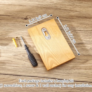 May include: A rectangular light-colored wooden plaque with a metal keyhole hanger on the back. The plaque measures 3.54 inches by 5.51 inches. Included are a small screwdriver, a metal screw, and a yellow plastic wall anchor for installation.