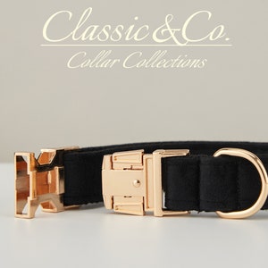 May include: Black dog collar with gold-tone hardware. The collar has a buckle closure and a D-ring for attaching a leash. The collar is made of a soft, durable material.