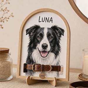 May include: An arched wooden frame holding a portrait of a black and white dog with the name LUNA printed above. A brown leather dog collar with a gold buckle and a round metal tag engraved with the name LUNA is attached across the portrait.