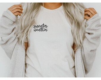 May include: A white t-shirt with the text "sweater weather" written in black cursive script.