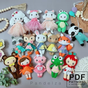 Könnte beinhalten: Ein Set mit 15 Filz-Tier- und Figuren-Anhängern, darunter ein Fuchs, ein Reh, ein Schwein, ein Frosch, eine Katze, ein Waschbär, ein Bär, ein Kaninchen, ein Pudel, eine Krabbe, ein Mädchen mit einer roten Schleife, ein Mädchen mit einem Krabbenkostüm, ein Mädchen mit einem Schweinekostüm, ein Frosch mit einem Donut und ein Panda. Die Anhänger sind alle handgefertigt und haben verschiedene Farben und Muster. Der Text "PDF Patterns & Instructions" ist in der rechten unteren Ecke des Bildes sichtbar.