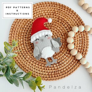 May include: A gray felt owl wearing a red Santa hat with a white pom-pom on top. The owl is sitting on a woven wicker placemat. The text "PDF PATTERNS & INSTRUCTIONS" is in the upper left corner of the image. The text "Pandeliza" is in the lower right corner of the image.