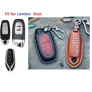 May include: Image of car keys and leather key cases. The keys are black and silver. The key cases are brown and black with silver keychains. The text "Fit for Lambor Keys" is at the top of the image.