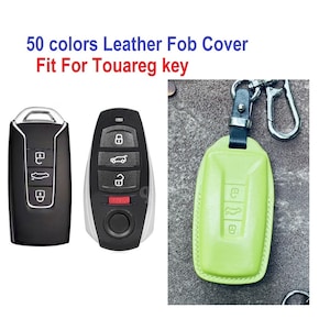 Peut inclure: Un couvre-clé en cuir vert avec un porte-clés. Le couvre-clé a un bord cousu et est conçu pour s'adapter à une clé Volkswagen Touareg. Le texte "50 couleurs Leather Fob Cover Fit For Touareg key" est affiché au-dessus de l'image.