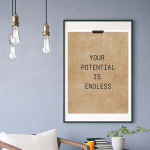 Könnte beinhalten: Ein gerahmter Druck mit braunem Hintergrund und dem Text "YOUR POTENTIAL IS ENDLESS" in Schwarz.