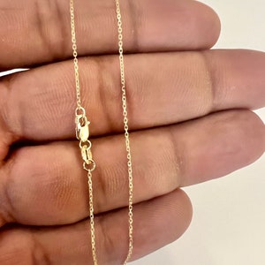 May include: A gold chain necklace with a lobster clasp.