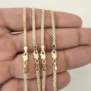 May include: Four gold-colored necklaces with a textured chain design. Each necklace has a lobster clasp closure. The clasps are marked with "14K" and "DR". The necklaces are displayed against a neutral background.