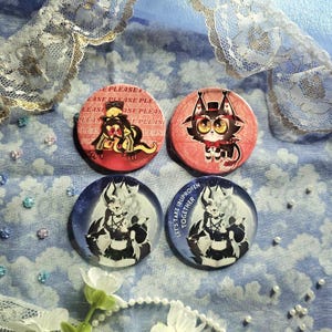 Puede incluir: Cuatro botones redondos con diseños de personajes de dibujos animados. Dos botones tienen fondos rojos, uno con el texto "PLEASE" y el otro con un personaje parecido a un gato. Los otros dos botones tienen fondos azules y un personaje blanco, uno con el texto "LET'S TAKE IBUPROFEN TOGETHER."