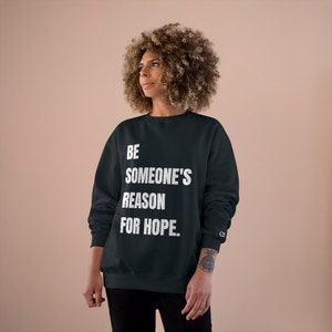 May include: Black sweatshirt with white text that reads "BE SOMEONE'S REASON FOR HOPE."