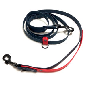 Könnte beinhalten: Eine blaue und rote Hundeleine mit einem Metallclip und einem Ring. Die Leine ist aus strapazierfähigem Material gefertigt und für den täglichen Gebrauch konzipiert.