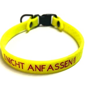 Può includere: Un collare per cani giallo brillante con fibbia nera e anello a D. Il collare presenta il testo tedesco "!!NICHT ANFASSEN!!" in lettere rosse. Il collare è realizzato in materiale flessibile.