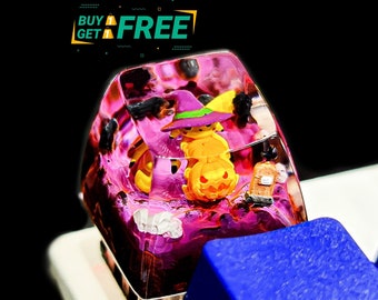 Pode incluir: Uma tecla de resina rosa e roxa com um design temático de Halloween que apresenta uma bruxa e uma abóbora. A tecla está em um teclado azul.