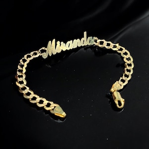 May include: A gold chain bracelet with the name "Miranda" engraved on it.