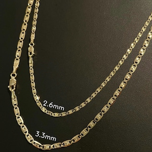 May include: Two gold chains with a mariner link pattern. The chain on the top is 2.6 mm wide and the chain on the bottom is 3.3 mm wide.