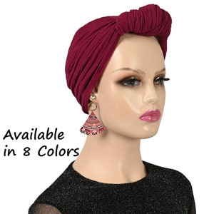 Puede incluir: Un turbante de estilo chal en tejido suave de color burdeos. Disponible en 8 colores.