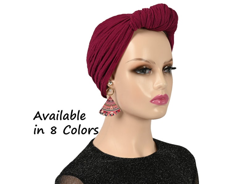 Puede incluir: Un turbante de estilo chal en tejido suave de color burdeos. Disponible en 8 colores.
