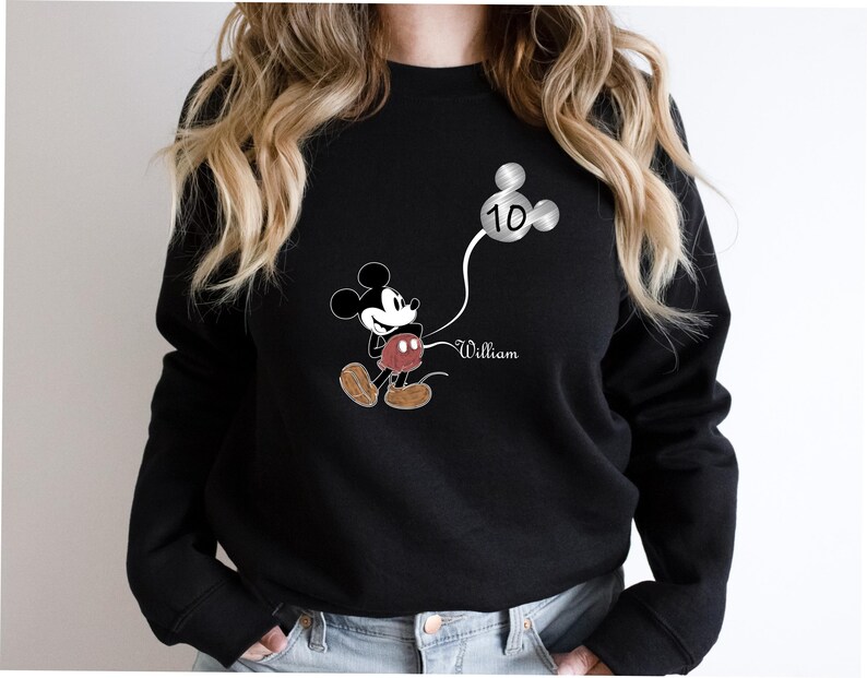 Puede incluir: Sudadera negra con un gr&aacute;fico de Mickey Mouse sosteniendo un globo plateado que dice "10" y el nombre "William" impreso debajo.