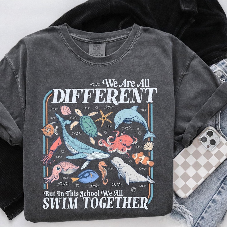 Artwork shows an assortment of ocean creatures like whales, dolphins, turtles, fish, squid, and octopus, arranged around a unity-themed message for schools.
