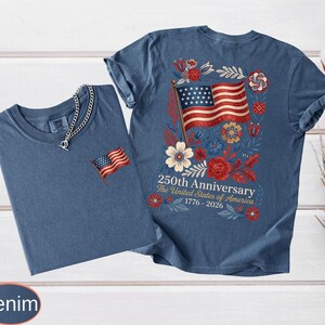 May include: Two denim blue t-shirts. One has a small embroidered American flag on the chest. The other has a large graphic on the back with an American flag, flowers, and text that reads "250th Anniversary The United States of America 1776-2026."
