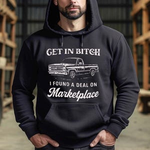 May include: Black hooded sweatshirt with white text and a truck graphic. The text reads "GET IN BITCH" above a drawing of a pickup truck, and "I FOUND A DEAL ON Marketplace" below.