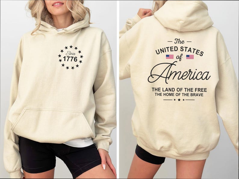 Pu&ograve; includere: Felpa con cappuccio color crema con tasca frontale e cappuccio. La parte anteriore presenta un design circolare con la scritta "Since 1776". Il retro mostra "The United States of America" con bandiere e le frasi "The Land of the Free" e "The Home of the Brave."