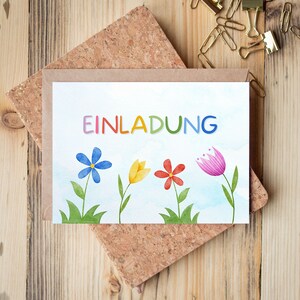 May include: A white card with the word "EINLADUNG" in rainbow letters. The card is decorated with watercolor illustrations of flowers in blue, yellow, pink, and red.