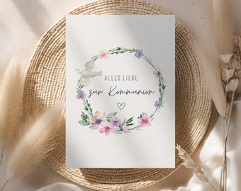 May include: A white card with a watercolour wreath of pink, purple and yellow flowers. A white dove flies above the wreath. The text "Alles Liebe zur Kommunion" is written in the centre of the wreath.