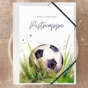 Könnte beinhalten: Eine weiße Karte mit dem Text "Eren Öğretmen Postmappe" in blauer Schrift. Eine Aquarell-Illustration eines Fußballs im grünen Gras.